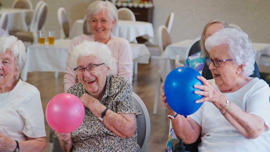 A senior resident personalizing their apartment with family photos and keepsakes.