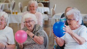 A senior resident personalizing their apartment with family photos and keepsakes.